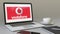 Opening laptop with Vodafone logo on the screen. Modern workplace conceptual editorial 4K clip