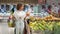 Opening store, woman with grocery basket gets fresh vegetables supermarket