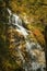 Openings in colorful fall foliage reveal Cloudland Falls, New Ha