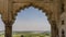 Through the openwork arched vault of the Musamman Burj Palace you can see the green valley