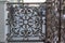 An openwork cast iron lattice adorns the porch of the house