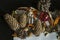 Openwork paper napkin with various pine cones, fir branch, old Christmas toys, almonds and orange peel on black background