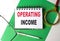 OPERATING INCOME text on notebook on green paper