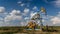 Operating oil and gas well profiled on cloudy sky