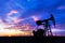 Operating oil and gas well and sunset sky