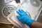 In  operating theatre an instrument container is cleaned and disinfected by one hand with blue gloves