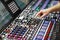 Operator adjusts controls of audio mixer panel