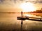 Operator of drone drives it to film and take photos of films foggy bright sunrise over lake and trees, standing with his back to