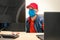 Operator works in the office during the quarantine.A man in a medical mask sits in front of the monitor screens. Specialist works