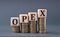 OPEX - acronym on wooden cubes on coins on a gray background
