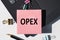 OPEX Operational Expenditures note is written on a paper sticker on a laptop keyboard