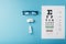 Ophthalmic Accessories Glasses and lenses with an Eye Test Chart for vision correction on a blue background