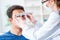 The ophthalmologist is checking up patient in eye doctor hospital