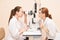 Ophthalmologist doctor in exam optician laboratory with female patient. Eye care