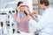 ophthalmologist helping patient choose glasses with needed lenses