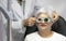 Ophthalmologist measures eyesight for an elderly woman
