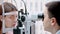 Ophthalmologist - an ophthalmologist is checking the eyesight of a beautiful woman using a special apparatus