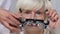 Ophthalmologist putting phoropter on elderly woman eyes, vision examination