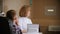 Ophthalmologist treatment - mature woman doctor sitting by the table with a little boy - boy looking at the wall