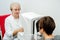 Ophthalmologist woman examining young woman eyes in clinic.