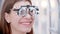 Ophthalmologist - woman is sitting in special glasses and smiling