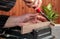 Opposite angle view of a carpenter`s hands, working on a wooden plank with chisel, closeup