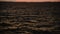 Optical zoom out from a gold sky reflection on a sunset river water surface with stormy waves