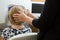 Optician Adjusting Female Patient\'s Head For