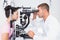 Optician examining womans eyes through slit lamp