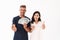 Optimistic adult loving couple isolated over white wall background holding money and credit card showing thumbs up