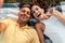 Optimistic adult loving couple lies outdoors in a beautiful green nature park take a selfie by camera