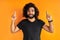 Optimistic bearded young man points upwards with both index fingers