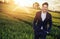 Optimistic businessman relaxing on the wheat field