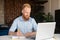 Optimistic ginger-head businessman in formal shirt using laptop