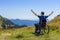 Optimistic handicapped man sitting on wheelchair on mountain