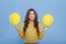 Optimistic stylish teenager holding two yellow balloons