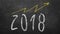 Optimistic year graph drawn on the blackboard. handwritten 2018 year inscription with growing yellow arrow