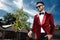 Optimistic young man wearing red velvet tuxedo outdoor