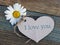 Option card for mother, grandmother, loved one.delicate white daisy and a heart of gray paper on a cosy wooden board. the concept