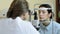 Optometrist examining female patient on slit lamp