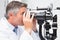 Optometrist looking in optical instrument