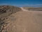 Opyspace of road trip through dried dusty rock mountain landscape ground of Namib desert with splitting stone and blue sky