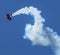 Oracle stunt bi-plane twisting in the sky leaving trail of smoke