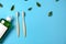 Oral care products. Mouthwash, two wooden bamboo eco friendly toothbrushes, green leaf on blue background. Teeth hygiene concept.