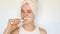 Oral hygiene and dental care. Healthy teeth and gums. Charming optimistic woman wrapped in towel on her head brushing teeth with