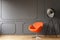 Orange armchair next to lamp in minimal living room interior wit