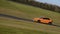 An orange Audi A3 sportscar speeding round corners