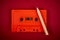 Orange audio cassette and pencil on dark red background
