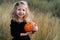 orange autumn pumpkin in children's hands with spiders in their hair, decor for the Halloween holiday