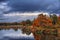 Orange autumn trees on riverbank. Golden Autumn Landscape